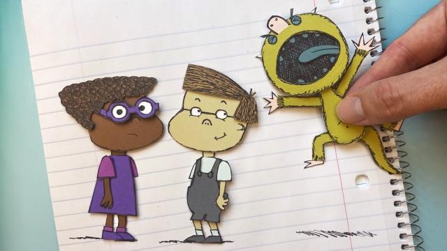 一只手拿着一个怪物角色的剪纸，并把它放在两个孩子角色的画旁边
